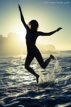 在海边跳跃的女人