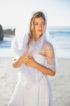 穿着白裙站在海滩上的女人