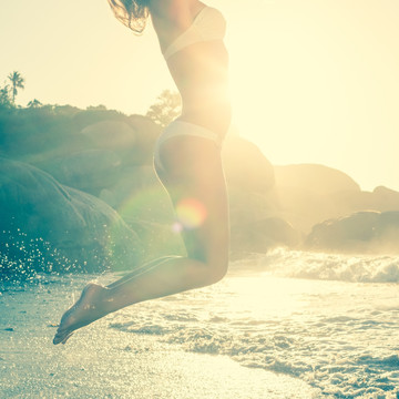 在海滩上跳跃的女人
