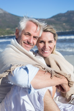 微笑的夫妇坐在沙滩上