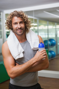 在健身房里拿着水瓶的男人
