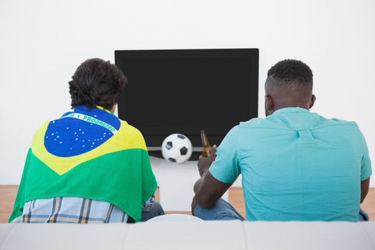 披着巴西国旗的球迷在看电视
