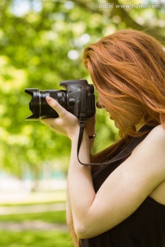 在公园里用相机拍照的女摄影师