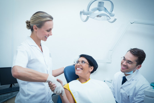 牙医微笑着和病人握手