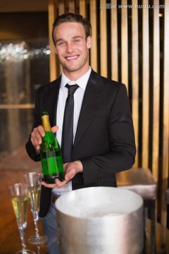 男服务员在酒吧里展示一盘香槟酒