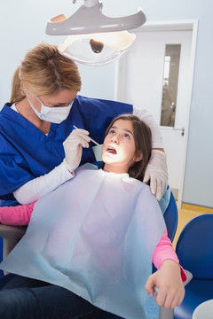 在个女孩检查牙齿的女医生