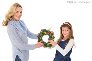 母亲和女儿拿着圣诞花环