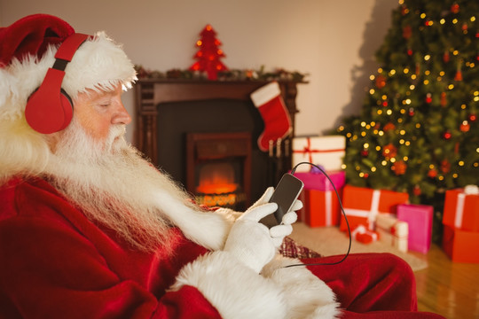圣诞老人用他的智能手机听音乐