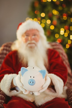 拿着小猪储钱罐的圣诞老人