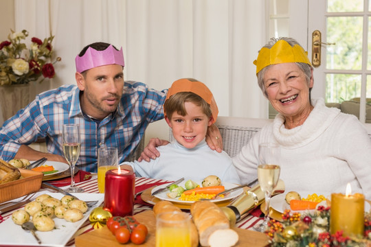 坐在餐桌前的父子和祖母