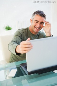 微笑着看着笔记本电脑的商务男人