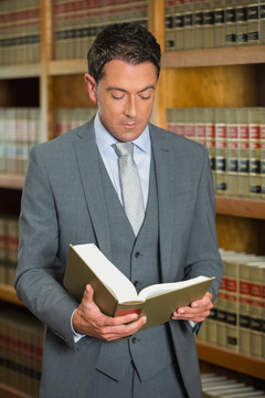 在图书馆里看法律书的男人