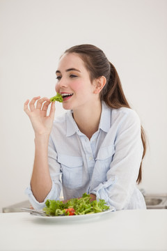 在吃一碗蔬菜沙拉的女人