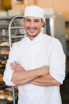 微笑的面包师抱着双臂站在厨房里