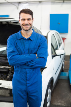 微笑的男汽车修理工抱着双臂