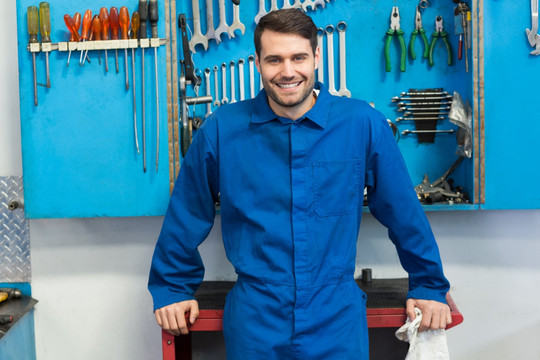 微笑的男技师在汽车修理厂