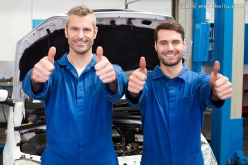 竖起大拇指的两名汽车修理工