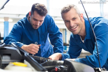 在维修汽车的两名汽车修理工