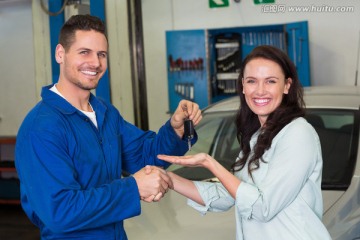 和汽车维修工握手的女顾客