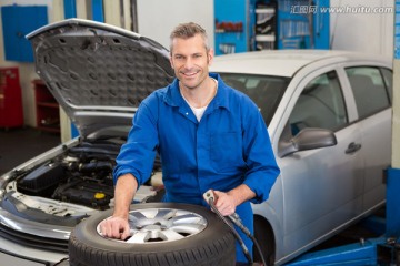 微笑的男机械师在汽车修理厂