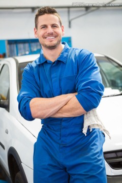 微笑的男汽车修理工抱着双臂