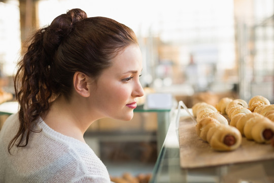 女人盯着面包店的点心