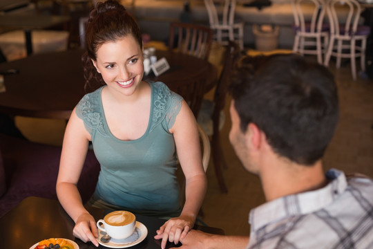 年轻夫妇在咖啡馆里一起喝咖啡