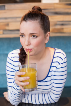 年轻女子喝一杯橙汁