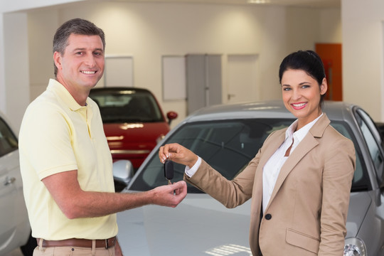 汽车销售员递一把车钥匙给客户