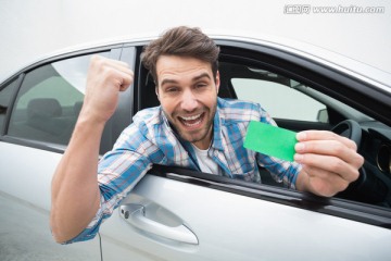 在车里拿着绿色卡片的男人
