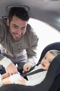 父亲在车里帮婴儿系安全带