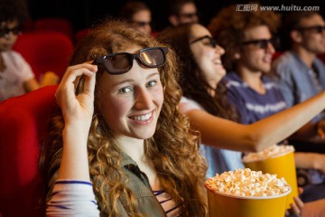 在电影院看电影吃爆米花的朋友们
