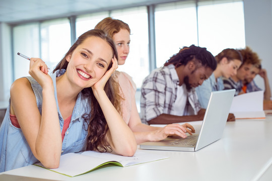 微笑的女大学生坐在教室里