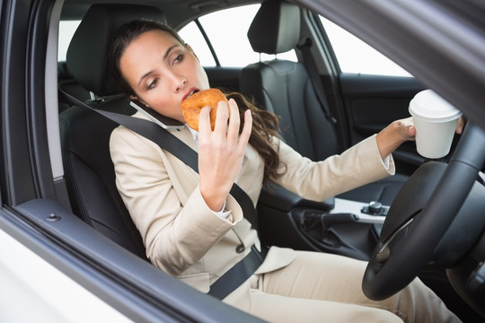 坐在车上吃面包的商务女人