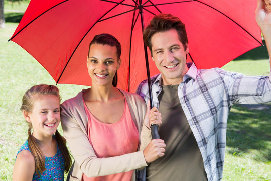 微笑着撑着伞的一家人