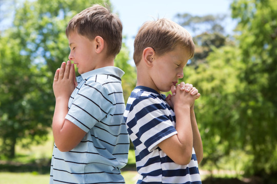 两个小男孩在公园里祈祷