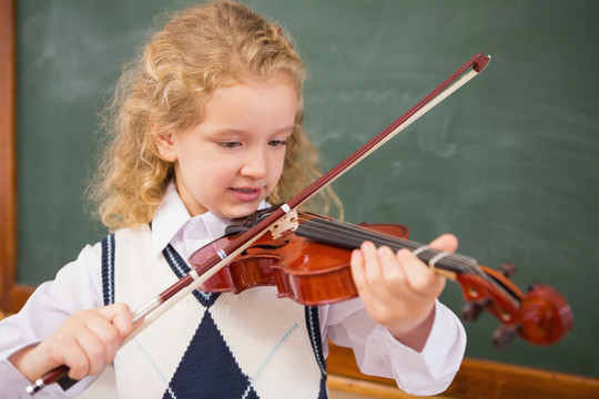 小学生在课堂上拉小提琴