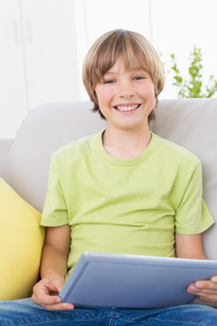 微笑着拿着平板电脑的男孩
