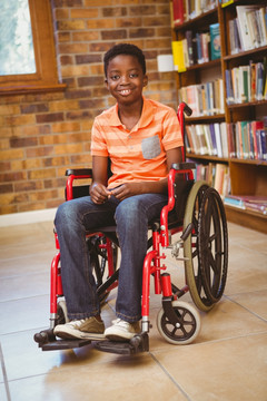微笑的小男孩坐在轮椅上