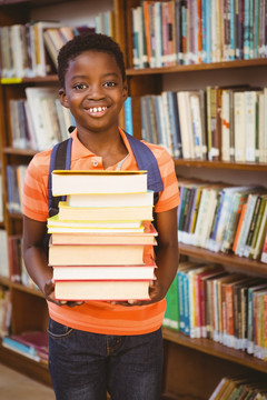 可爱的小男孩在图书馆抱着书