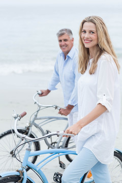在沙滩上骑自行车的夫妇