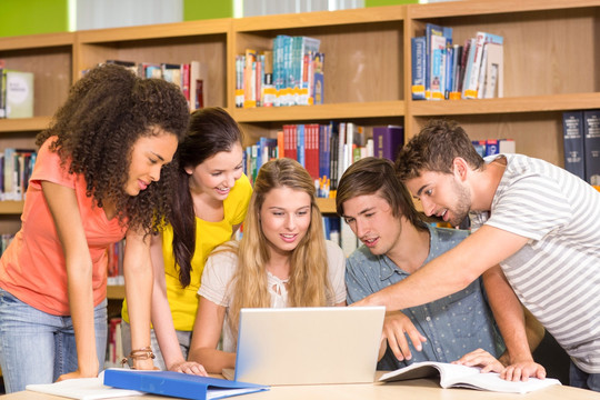 一群大学生在图书馆用笔记本电脑