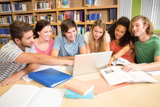一群大学生在图书馆用笔记本电脑