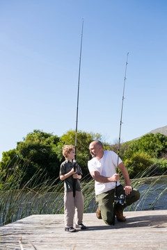 快乐的男人和他的儿子在乡下钓鱼