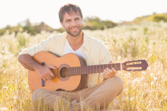坐在草丛里弹吉他的男人