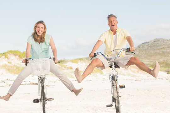 在海边骑自行车的夫妇