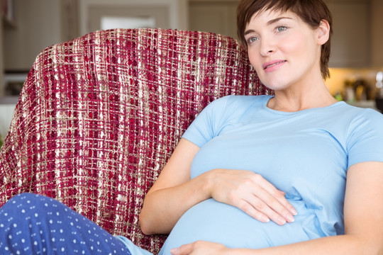 怀孕的女人在沙发上放松