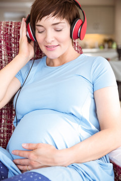 戴着耳机听音乐的孕妇