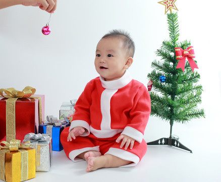 穿圣诞服装看着小球微笑的婴儿