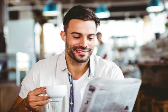 在咖啡馆里看报纸喝咖啡的男人